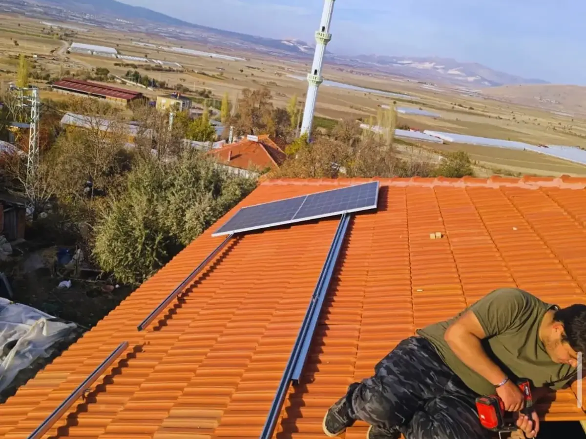 Kiremit çatıya güneş paneli taşıyıcı rayları monte eden teknisyen