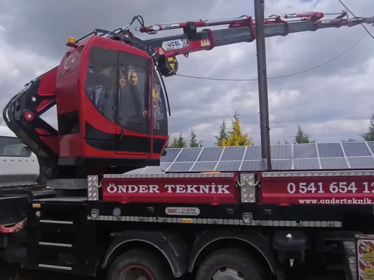 Vinçli araç, enerji nakil hattı direği yanında konumlanmış